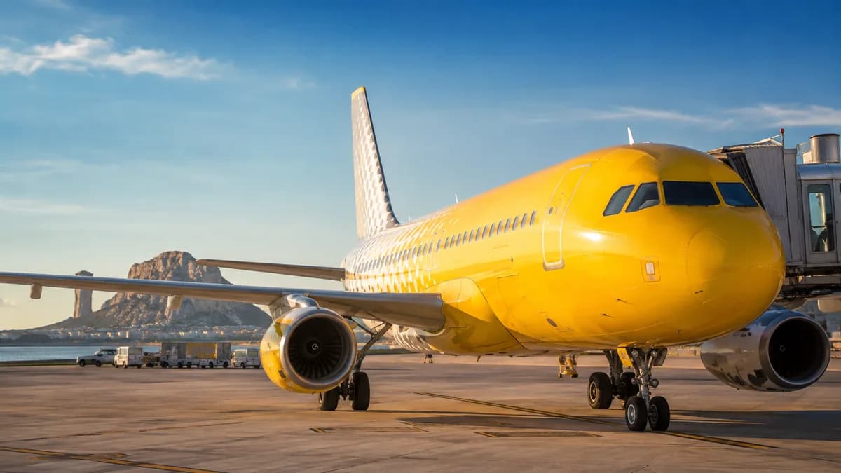 Avion Vueling jaune au sol devant l'aérogare, illustrant le remboursement des taxes Vueling